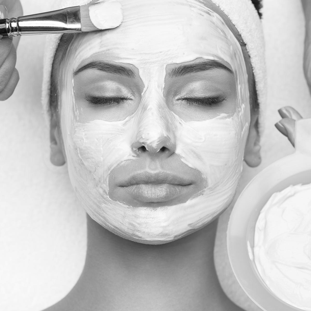 Young beautiful woman receiving  facial mask in spa beauty salon
