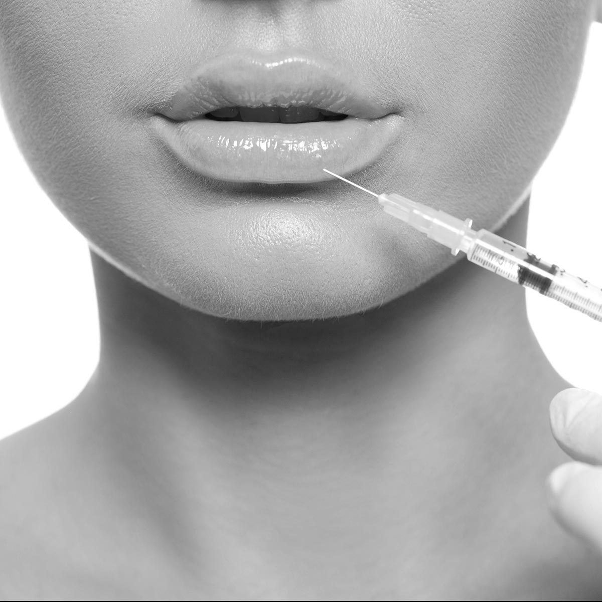 closeup beautiful woman face, syringe injection to lips beauty concept